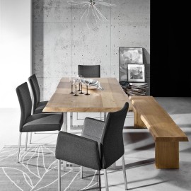 Stół MAILAND. Piękny, masywny stół w 100% wykonany z drewna dębowego, który zaskakuje kreatywnością nowoczesnego designu. Rolę nóg spełniają w nim dwie płozy z efektem stali nierdzewnej. Unikatowy charakter stołu podkreśla krawędź o obłej linii. Stół ten został zaprojektowany z myślą o wymagającym użytkowniku ceniącym
